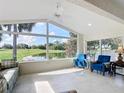 Bright sunroom boasting large windows, tile flooring, and serene views of the golf course and pond at 1008 Jackson St, The Villages, FL 32162