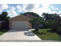 Lovely single-story house featuring a well-maintained lawn, mature tree, and a spacious driveway at 1021 Golfside Ct, Kissimmee, FL 34741