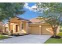 Well-maintained single-Gathering home featuring a two-car garage and tidy landscaping at 10580 Moss Rose Way, Orlando, FL 32832