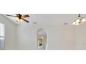 Bright living room featuring neutral walls, a ceiling fan and an arched doorway at 10580 Moss Rose Way, Orlando, FL 32832