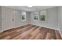 Bright bedroom with wood-look flooring, neutral walls, and natural light from two windows at 1310 Coletta Dr, Orlando, FL 32807