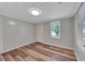 Cozy bedroom featuring wood-look floors, fresh paint and a bright window at 1310 Coletta Dr, Orlando, FL 32807