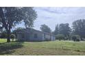 Charming single story home with manicured lawn, mature trees, and updated exterior at 13208 Massachusetts Ave, Astatula, FL 34705
