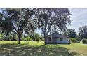 Quaint single story home with shade trees in front and beautiful landscaping in the front yard at 13208 Massachusetts Ave, Astatula, FL 34705