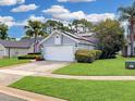 Well-manicured lawn and landscaped garden beds accentuate this single-Gathering home, creating a welcoming curb appeal at 14529 Falling Tree Ct, Orlando, FL 32837