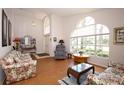 Bright living room with large arched windows, wood floor, and floral sofas at 1546 Royal Cir, Apopka, FL 32703