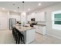 Modern kitchen features a large island with seating, stainless steel appliances, and white cabinets at 1997 Standing Rock Cir, Oakland, FL 34787