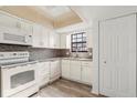 Bright kitchen featuring white appliances, mosaic backsplash, and ample cabinet space with a cozy feel at 2250 S Palmetto Ave # I-11, Daytona Beach, FL 32119