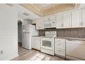 Well-lit kitchen with white appliances, wood flooring, and a tiled backsplash at 2250 S Palmetto Ave # I-11, Daytona Beach, FL 32119