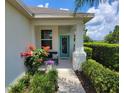 Inviting covered front porch with a teal door and cozy seating area at 3458 Sagebrush St, Harmony, FL 34773