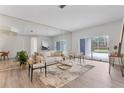 Bright living room featuring hardwood floors, stylish seating, and sliding glass doors to the pool area at 4110 Maplegrove Dr, Orlando, FL 32818