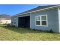 Exterior view of the home featuring blue siding and trim, plus a screened-in porch at 4167 Clifden Dr, Ormond Beach, FL 32174