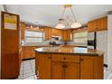 Spacious kitchen with a central island, wooden cabinets, and modern appliances at 5324 Barefoot Path, Kissimmee, FL 34746
