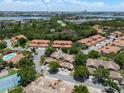 Expansive aerial view of a residential neighborhood with a community pool and tennis courts at 7856 Sugar Bend Dr # 7856, Orlando, FL 32819