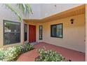 Welcoming front porch with a bright red door and surrounding green landscaping at 7856 Sugar Bend Dr # 7856, Orlando, FL 32819