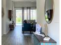 Hallway view of living room showing sliding glass doors to pool with hardwood-style floors at 8023 King Palm Cir, Kissimmee, FL 34747