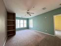 Bedroom with neutral carpet, ceiling fan, a window and built-in shelving at 8929 Legacy Ct # 208, Kissimmee, FL 34747