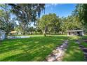 Expansive backyard featuring lush greenery, a pool, and additional outbuilding, perfect for outdoor activities and storage at 1206 Culver Rd, Orlando, FL 32825