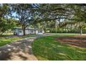 Well-maintained home with a long driveway leading to the front entrance, surrounded by mature landscaping and trees at 1206 Culver Rd, Orlando, FL 32825
