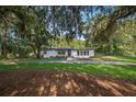 Charming single-story home showcasing a manicured lawn and beautiful mature trees at 1206 Culver Rd, Orlando, FL 32825