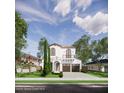 Attractive two-story house displaying an arched entry, balcony, two-car garage, and neat front yard landscaping at 1473 Berkshire Ave, Winter Park, FL 32789