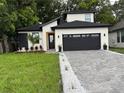 Charming home with a well-manicured lawn, a brick driveway, and a gray two-car garage at 1526 Hempel Ave, Gotha, FL 34734