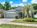 Well-maintained home with a two-car garage, green lawn, and mature trees offering curb appeal at 1712 Riveredge Rd, Oviedo, FL 32766
