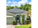 Close-up of home showcasing the front entry with an arched doorway and manicured landscaping at 1712 Riveredge Rd, Oviedo, FL 32766