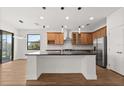 Bright open-concept kitchen features a granite island, modern pendant lighting, and stainless steel appliances at 212 Lugano Way, Debary, FL 32713
