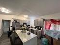 Modern kitchen features gray cabinets, stainless steel appliances, and an island with seating at 223 Hope Cir, Orlando, FL 32811