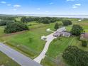 Property featuring a long driveway, spacious lawn, multiple buildings, and mature trees, fully fenced with lake views at 2921 Lake Tohopekaliga Blvd, Kissimmee, FL 34746