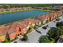 A beautiful aerial view of colorful townhomes situated alongside a serene lake in a well-maintained community at 3061 Beach Palm Ave, Kissimmee, FL 34747