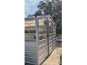 This is a side view of a metallic greenhouse with translucent roof and walls, with a door for easy access at 32645 Red Oak Dr, Eustis, FL 32736