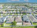 Expansive aerial view highlighting the neighborhood, nearby lake, and the surrounding landscape on a sunny day at 3454 Somerset Park Dr, Orlando, FL 32824