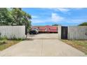 A charming house featuring a private driveway enclosed by white and black gates at 4051 Crofford Ave, Haines City, FL 33844