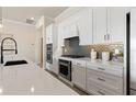 A modern kitchen featuring white cabinets, stainless steel appliances, and sleek countertops at 5101 Rising Ridge Dr, Mount Dora, FL 32757