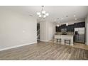 Open-concept kitchen and living area with dark cabinetry, granite countertops, and stainless steel appliances at 5669 New Independence Pkwy, Winter Garden, FL 34787