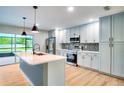 Modern kitchen features an island, stainless steel appliances, stone backsplash, light colored cabinets, and open design at 5938 Marlberry Dr, Orlando, FL 32819