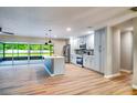 Spacious kitchen showcasing an island, stainless steel appliances, and sleek cabinets with backyard pool view at 5938 Marlberry Dr, Orlando, FL 32819