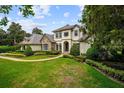 Beautiful two-story house with manicured lawns, mature landscaping, and an inviting walkway at 6138 Greatwater Dr, Windermere, FL 34786