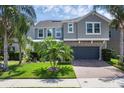 Beautiful two-story home with a paver driveway, lush landscaping, and a two-car garage at 617 Marsh Reed Dr, Winter Garden, FL 34787