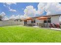 Spacious backyard with well-maintained lawn, patio furniture, and an orange umbrella at 840 Teton St, Haines City, FL 33844