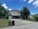Charming two-story home with a spacious driveway, attached two-car garage, and a mature palm tree in the front yard at 860 Charlotte St, Longwood, FL 32750