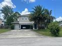 Charming two-story home with a spacious driveway, attached two-car garage, and a mature palm tree in the front yard at 860 Charlotte St, Longwood, FL 32750