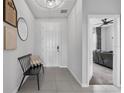 Inviting foyer features neutral gray walls, tile floors, modern bench, and a view into the living area at 944 Benjamin Trl, Davenport, FL 33837