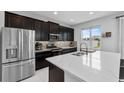 Modern kitchen with stainless steel appliances, quartz countertops and a large island with a view to the backyard at 944 Benjamin Trl, Davenport, FL 33837