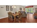 The dining area features a dark wood table set for seven, wood floors, and lots of natural light at 9440 Myrtle Creek Ln # 1003, Orlando, FL 32832