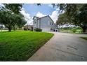 Spacious home featuring a three-car garage, large driveway, and expansive lawn near the lake at 13524 Lake Luntz Dr, Winter Garden, FL 34787