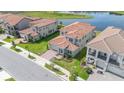 Scenic aerial view of neighborhood with a tranquil pond, lush landscaping, and terracotta-roofed homes at 13556 Abberwick Dr, Orlando, FL 32832