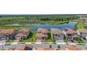 An aerial view showcasing the community's serene pond and lush greenery, with terracotta-roofed houses at 13556 Abberwick Dr, Orlando, FL 32832